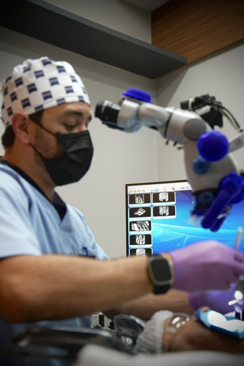 Dr. Virgílio Bastos trabalhando com o microscópio odontológico.